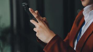 silhouette d'une photo recadrée d'un jeune homme travaillant à domicile à l'aide d'un smartphone et d'un ordinateur portable, les mains de l'homme utilisant un smartphone à l'intérieur, un homme sur son lieu de travail utilisant la technologie, une lumière parasite video