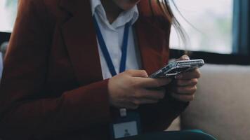 Silhouette of cropped shot of a young man working from home using smart phone and notebook computer, man's hands using smart phone in interior, man at his workplace using technology, flare light video