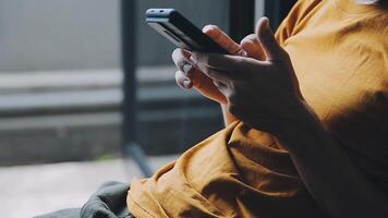 silhouette d'une photo recadrée d'un jeune homme travaillant à domicile à l'aide d'un smartphone et d'un ordinateur portable, les mains de l'homme utilisant un smartphone à l'intérieur, un homme sur son lieu de travail utilisant la technologie, une lumière parasite video