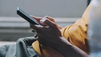 silhouette d'une photo recadrée d'un jeune homme travaillant à domicile à l'aide d'un smartphone et d'un ordinateur portable, les mains de l'homme utilisant un smartphone à l'intérieur, un homme sur son lieu de travail utilisant la technologie, une lumière parasite video