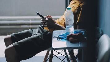 silhueta de tiro recortado de um jovem trabalhando em casa usando telefone inteligente e notebook, mãos do homem usando telefone inteligente no interior, homem em seu local de trabalho usando tecnologia, sinalizador de luz video