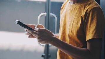 silhouette d'une photo recadrée d'un jeune homme travaillant à domicile à l'aide d'un smartphone et d'un ordinateur portable, les mains de l'homme utilisant un smartphone à l'intérieur, un homme sur son lieu de travail utilisant la technologie, une lumière parasite video