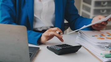 Business woman using calculator for do math finance on wooden desk in office and business working background, tax, accounting, statistics and analytic research concept video