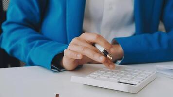 Business woman using calculator for do math finance on wooden desk in office and business working background, tax, accounting, statistics and analytic research concept video