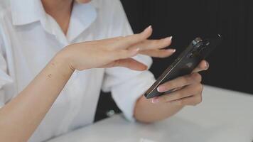 silhueta de tiro recortado de um jovem trabalhando em casa usando telefone inteligente e notebook, mãos do homem usando telefone inteligente no interior, homem em seu local de trabalho usando tecnologia, sinalizador de luz video