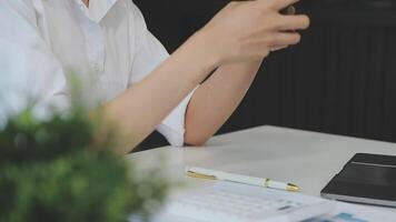 silhouette di ritagliata tiro di un' giovane uomo Lavorando a partire dal casa utilizzando inteligente Telefono e taccuino computer, dell'uomo mani utilizzando inteligente Telefono nel interno, uomo a il suo posto di lavoro utilizzando tecnologia, bagliore leggero video