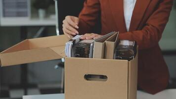 Upset female employee packing belongings in box, frustrated stressed girl getting fired from job ready to leave on last day at work. sad office worker desperate from work video