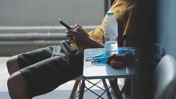 silhueta de tiro recortado de um jovem trabalhando em casa usando telefone inteligente e notebook, mãos do homem usando telefone inteligente no interior, homem em seu local de trabalho usando tecnologia, sinalizador de luz video