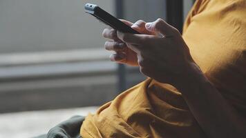 silhueta de tiro recortado de um jovem trabalhando em casa usando telefone inteligente e notebook, mãos do homem usando telefone inteligente no interior, homem em seu local de trabalho usando tecnologia, sinalizador de luz video