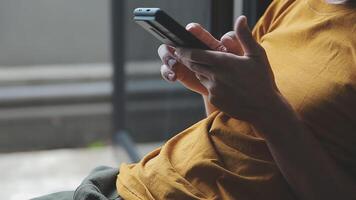 silhueta de tiro recortado de um jovem trabalhando em casa usando telefone inteligente e notebook, mãos do homem usando telefone inteligente no interior, homem em seu local de trabalho usando tecnologia, sinalizador de luz video