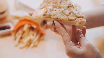 Happy woman eating slice of pizza at sidewalk cafe video