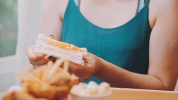 Mann im ein Restaurant Essen ein Hamburger, er ist hungrig und haben ein gut beissen. Burger Abendessen video