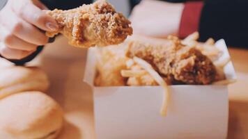 close up focus woman hand hold fried chicken for eat,girl with fast food concept video