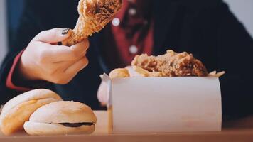 close up focus woman hand hold fried chicken for eat,girl with fast food concept video