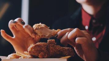 close up focus woman hand hold fried chicken for eat,girl with fast food concept video