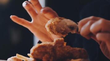 close up focus woman hand hold fried chicken for eat,girl with fast food concept video