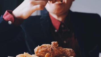 close up focus woman hand hold fried chicken for eat,girl with fast food concept video