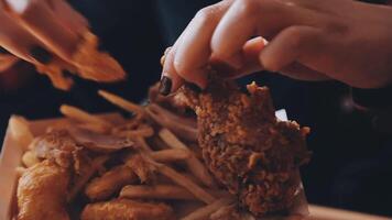 close up focus woman hand hold fried chicken for eat,girl with fast food concept video