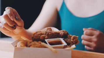 vicino su messa a fuoco donna mano hold fritte pollo per mangia, ragazza con veloce cibo concetto video