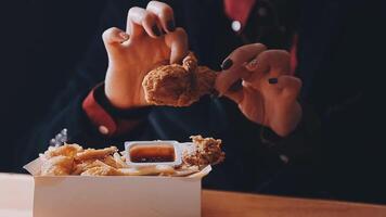 close up focus woman hand hold fried chicken for eat,girl with fast food concept video