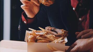 close up focus woman hand hold fried chicken for eat,girl with fast food concept video