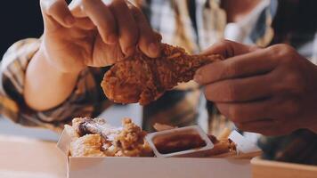 close up focus woman hand hold fried chicken for eat,girl with fast food concept video