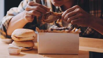 close up focus woman hand hold fried chicken for eat,girl with fast food concept video