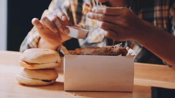 vicino su messa a fuoco donna mano hold fritte pollo per mangia, ragazza con veloce cibo concetto video