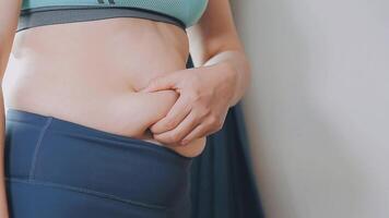 mujer cuerpo grasa barriga. obeso mujer mano participación excesivo barriga gordo. dieta estilo de vida concepto a reducir barriga y forma arriba sano estómago músculo. video