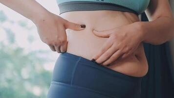 femmes corps graisse ventre. obèse femme main en portant excessif ventre graisse. régime mode de vie concept à réduire ventre et forme en haut en bonne santé estomac muscle. video