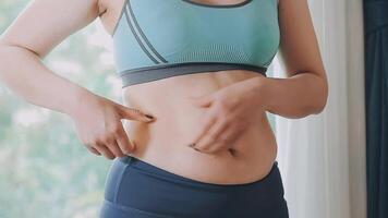 mujer cuerpo grasa barriga. obeso mujer mano participación excesivo barriga gordo. dieta estilo de vida concepto a reducir barriga y forma arriba sano estómago músculo. video