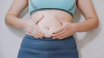 donne corpo Grasso gonfiarsi. obeso donna mano Tenere eccessivo pancia Grasso. dieta stile di vita concetto per ridurre pancia e forma su salutare stomaco muscolo. video