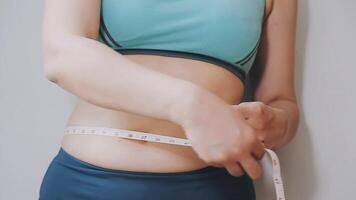 mujer cuerpo grasa barriga. obeso mujer mano participación excesivo barriga gordo. dieta estilo de vida concepto a reducir barriga y forma arriba sano estómago músculo. video