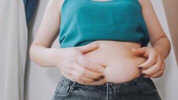 donne corpo Grasso gonfiarsi. obeso donna mano Tenere eccessivo pancia Grasso. dieta stile di vita concetto per ridurre pancia e forma su salutare stomaco muscolo. video