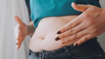 donne corpo Grasso gonfiarsi. obeso donna mano Tenere eccessivo pancia Grasso. dieta stile di vita concetto per ridurre pancia e forma su salutare stomaco muscolo. video