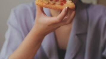 Happy woman eating slice of pizza at sidewalk cafe video