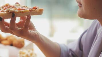 Happy woman eating slice of pizza at sidewalk cafe video