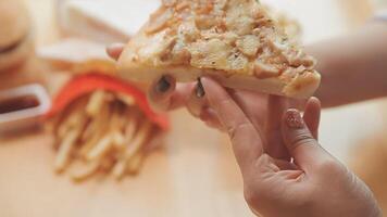 Happy woman eating slice of pizza at sidewalk cafe video