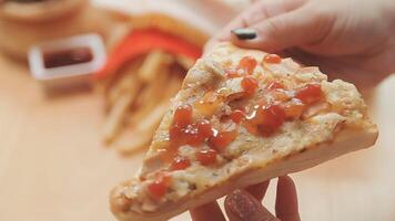 Happy woman eating slice of pizza at sidewalk cafe video