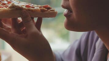 Happy woman eating slice of pizza at sidewalk cafe video