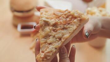 Happy woman eating slice of pizza at sidewalk cafe video