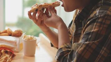 Happy woman eating slice of pizza at sidewalk cafe video