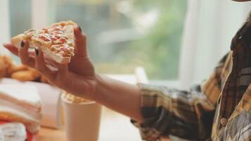 Happy woman eating slice of pizza at sidewalk cafe video