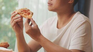 Happy woman eating slice of pizza at sidewalk cafe video