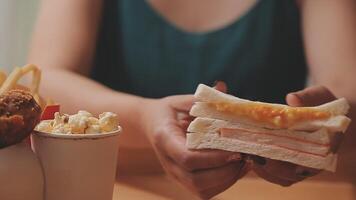 Mens in een restaurant aan het eten een Hamburger, hij is hongerig en hebben een mooi zo beet. hamburger avondeten video