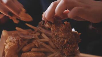 close up focus woman hand hold fried chicken for eat,girl with fast food concept video