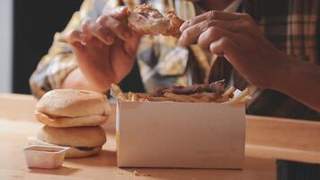 close up focus woman hand hold fried chicken for eat,girl with fast food concept video