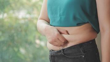 donne corpo Grasso gonfiarsi. obeso donna mano Tenere eccessivo pancia Grasso. dieta stile di vita concetto per ridurre pancia e forma su salutare stomaco muscolo. video