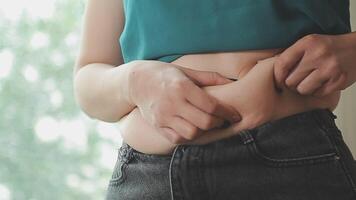 femmes corps graisse ventre. obèse femme main en portant excessif ventre graisse. régime mode de vie concept à réduire ventre et forme en haut en bonne santé estomac muscle. video