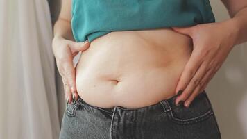 Women body fat belly. Obese woman hand holding excessive belly fat. diet lifestyle concept to reduce belly and shape up healthy stomach muscle. video